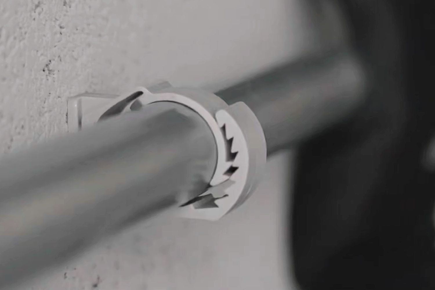 The STC Smart Tap Clamp fixing a conduit to a wall